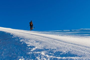 A skier jumping up on a hill